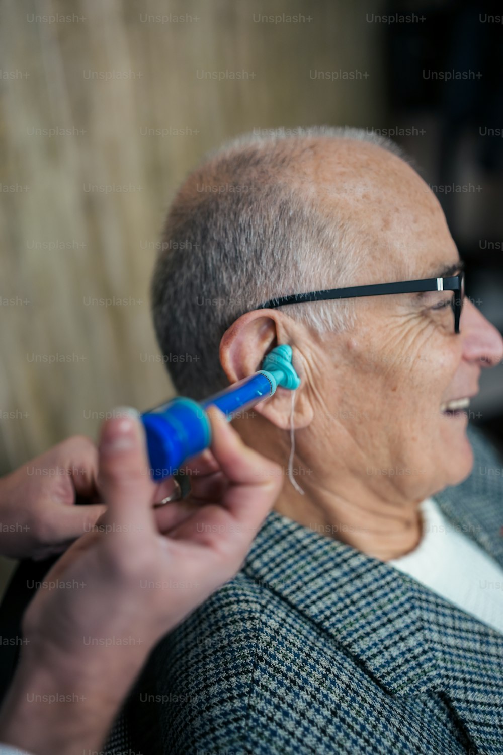 Ein älterer Mann lässt sein Ohr von einem Arzt untersuchen