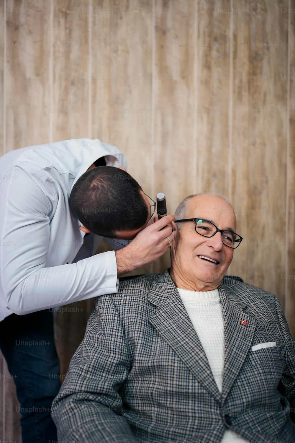 a man in a suit getting his hair cut