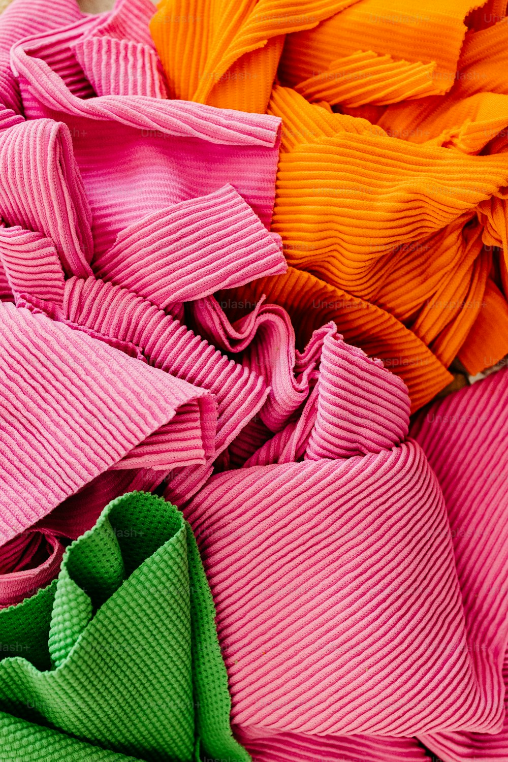 a pile of different colored cloths sitting on top of each other