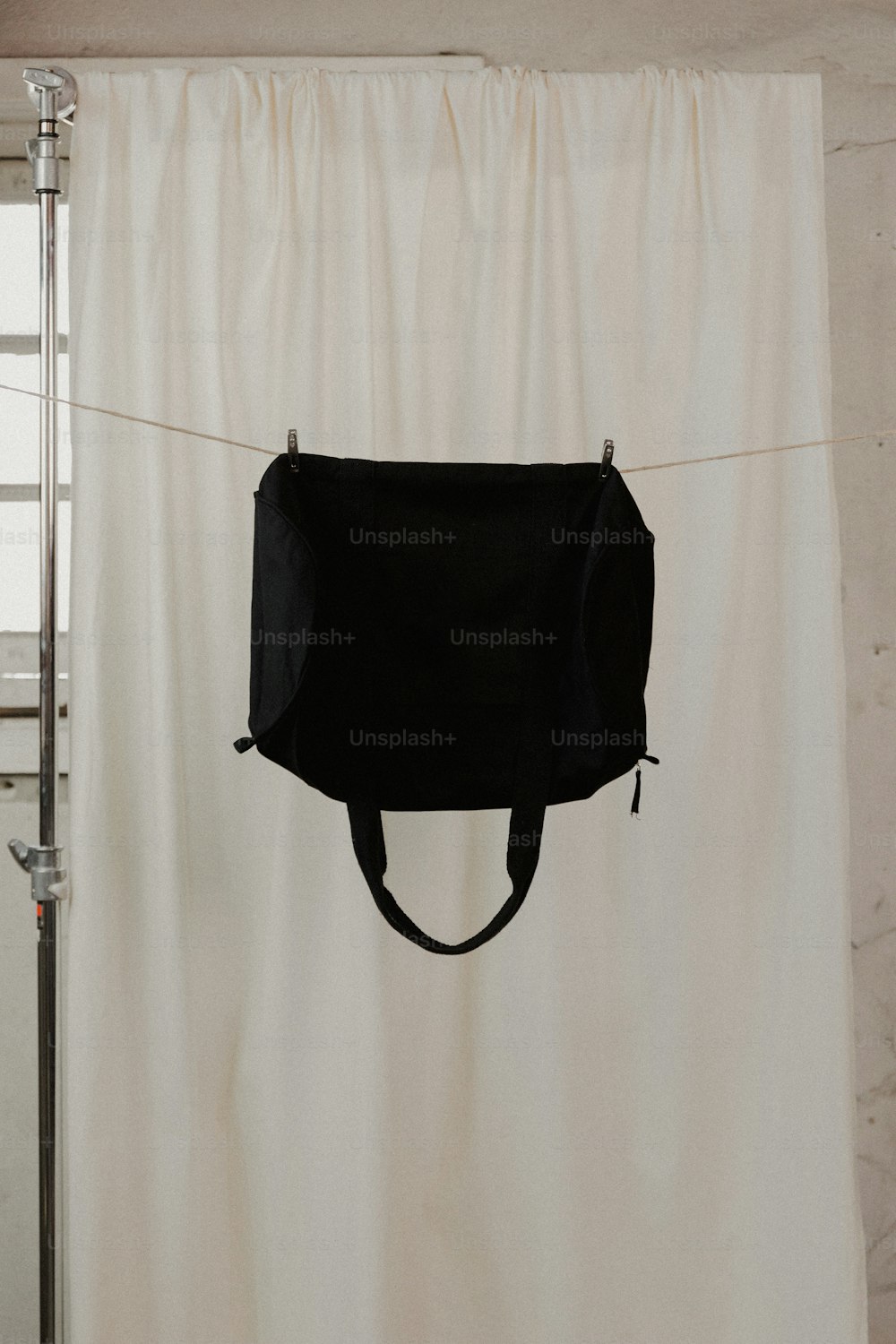 a white curtain with a black bag hanging from it