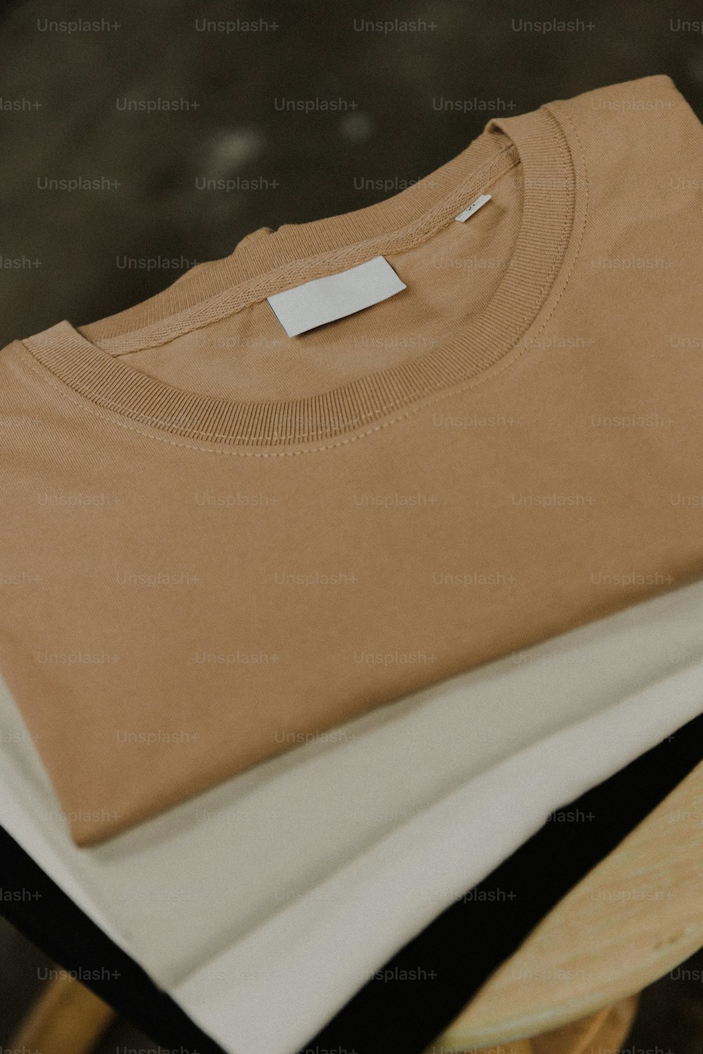 a pair of t - shirts sitting on top of a wooden chair