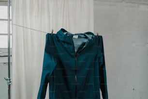 Una giacca verde appesa a una linea di vestiti