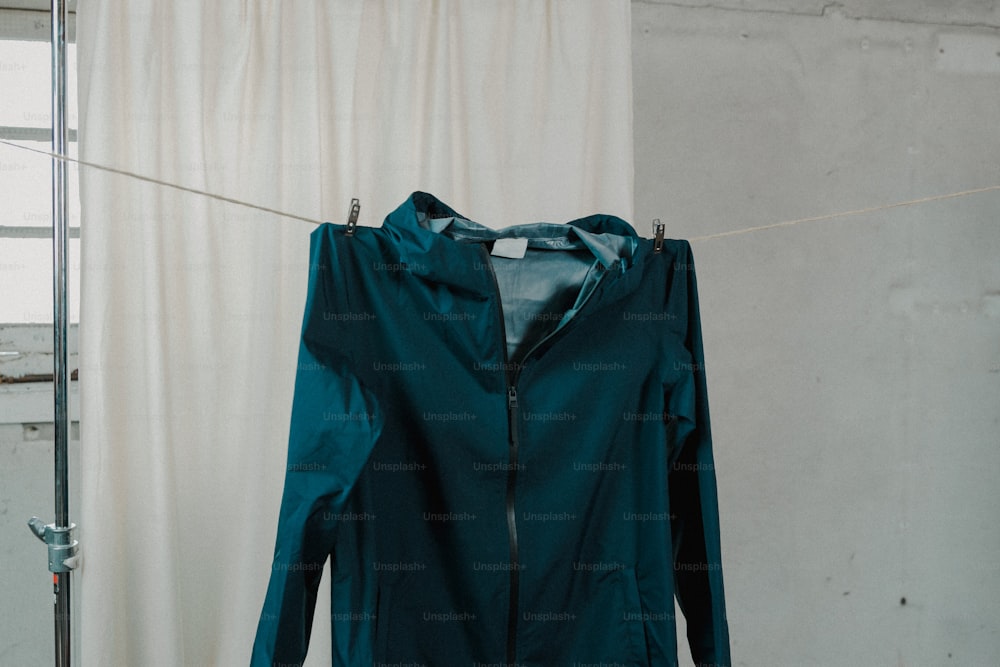 a green jacket hanging on a clothes line