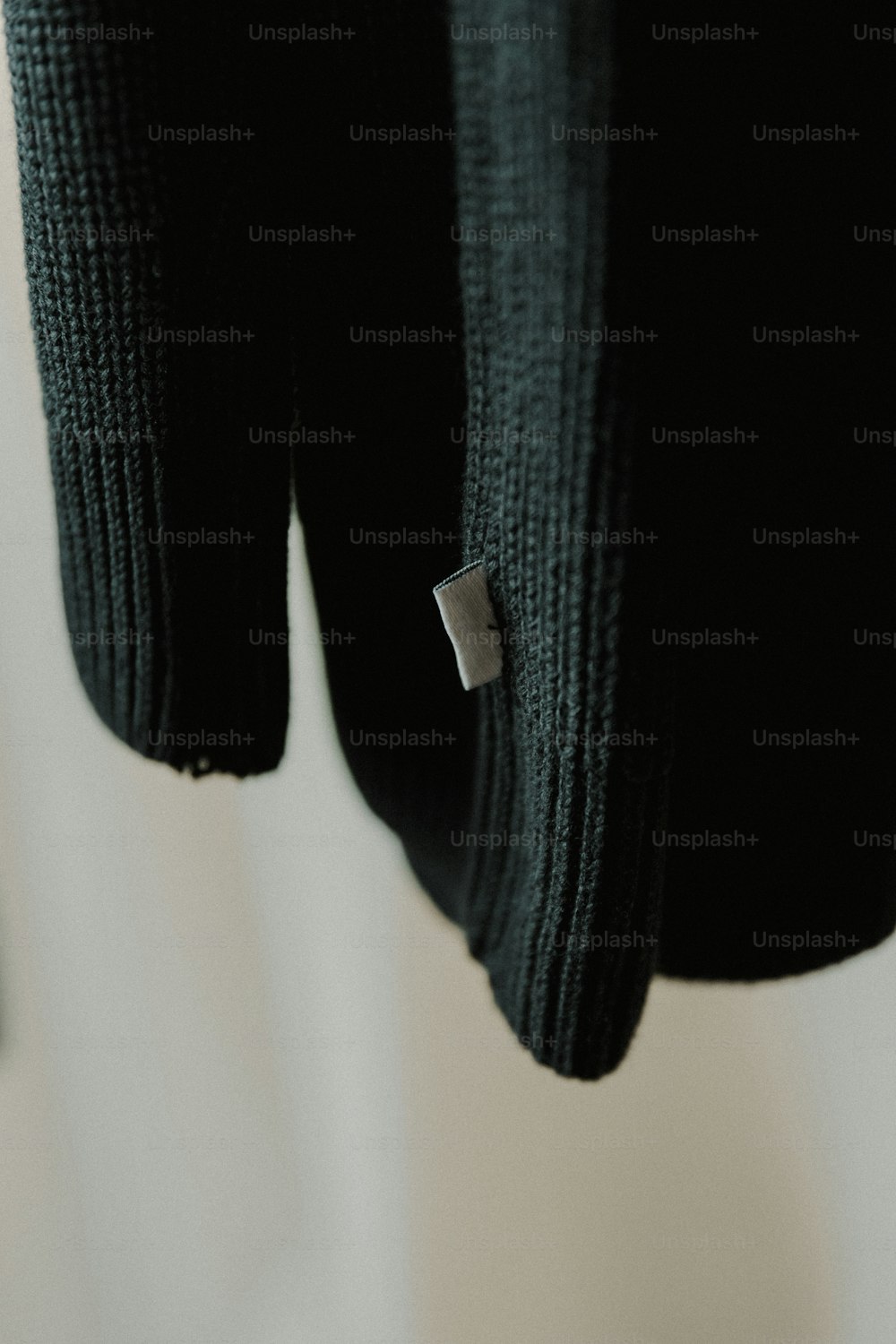 um close up de um suéter preto com um botão