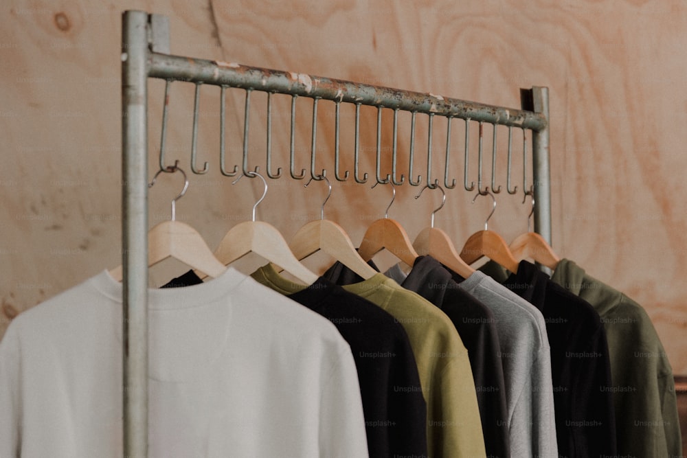 a rack of shirts hanging on a wooden wall