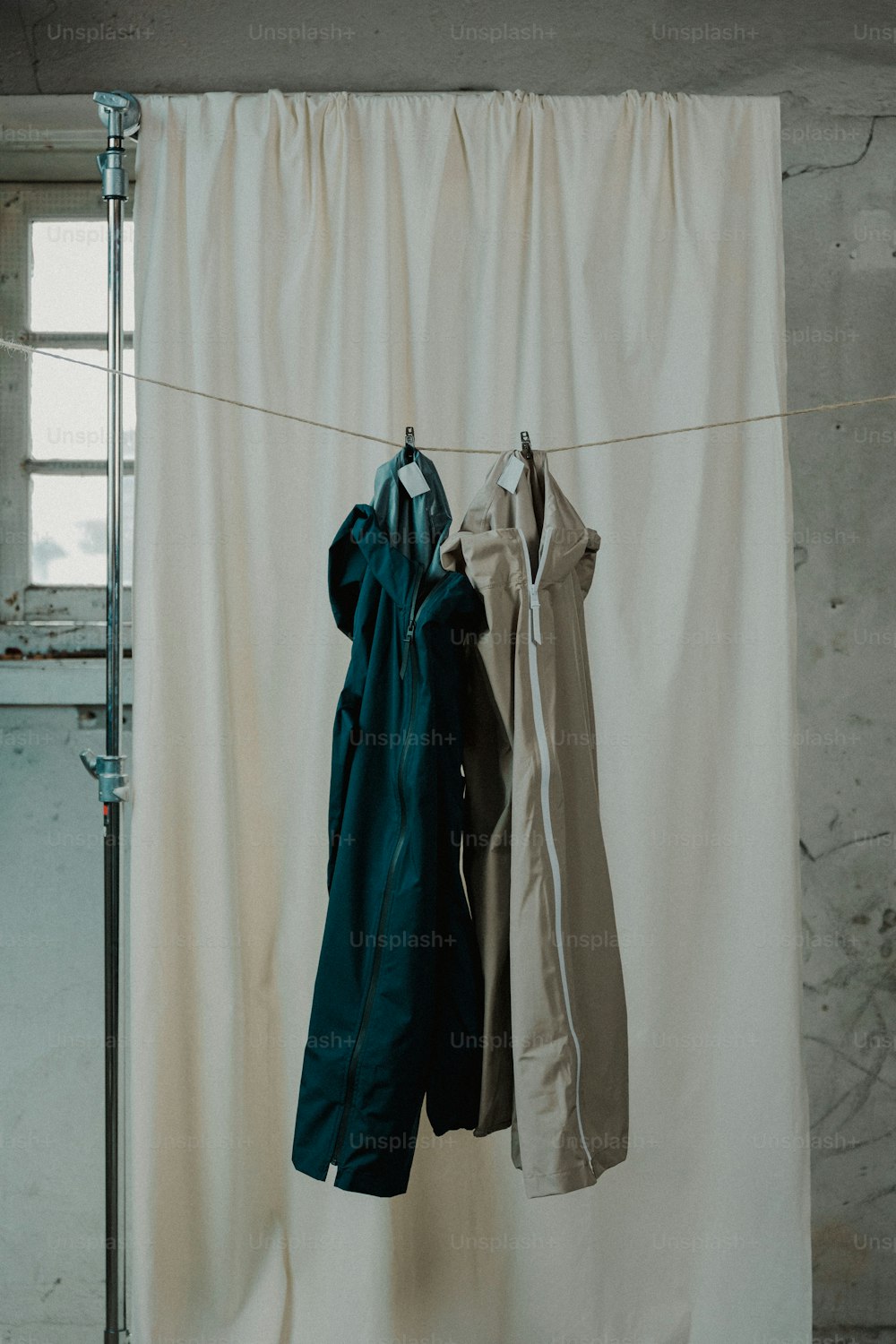 clothes hanging on a clothes line in front of a curtain