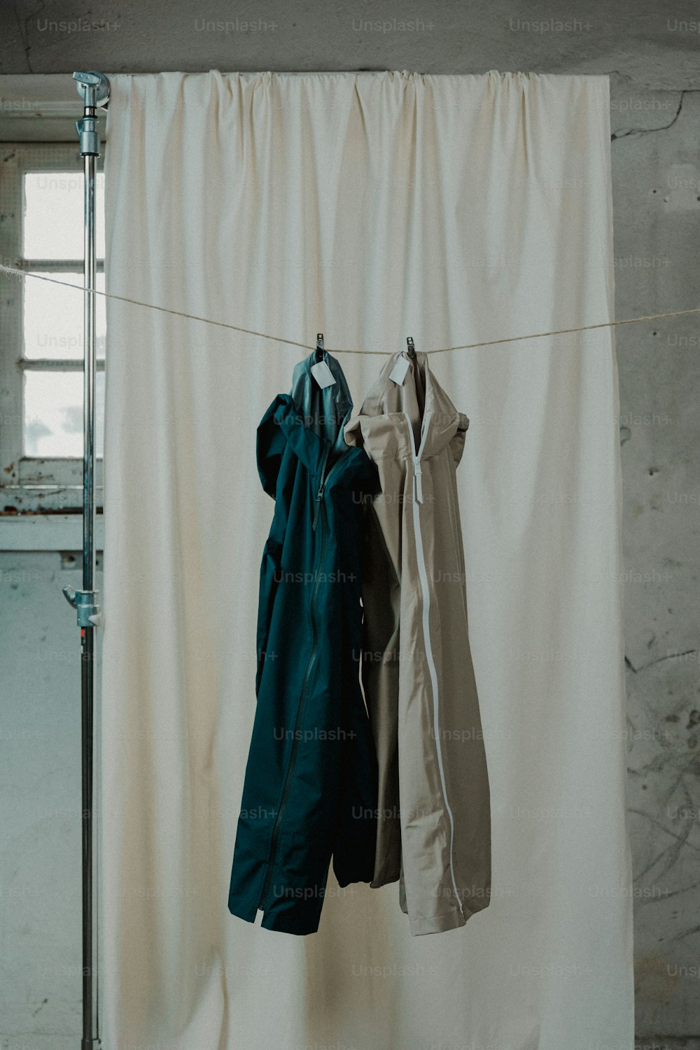 Kleidung, die an einer Wäscheleine vor einem Vorhang hängt