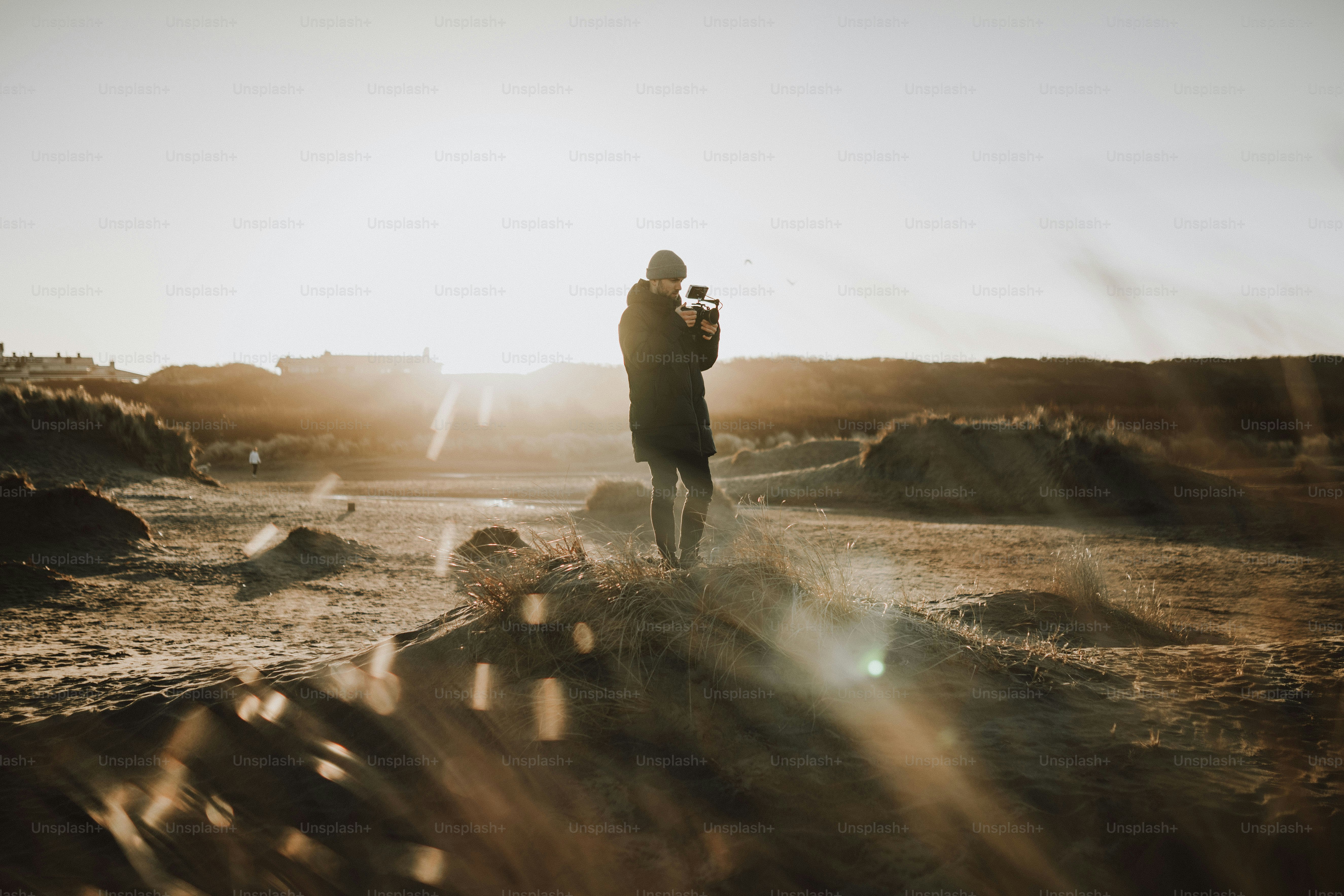 a person standing in a field with a camera
