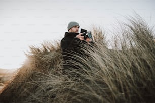 Ein Mann fotografiert ein hohes Gras