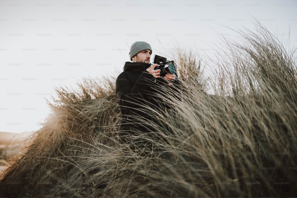 a man taking a picture of a tall grass