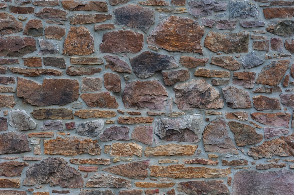 a close up of a stone wall with a clock on it