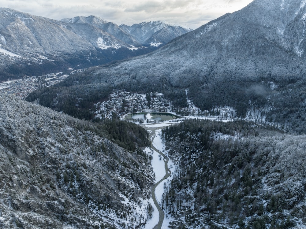 a snowy mountain valley with a road winding through it