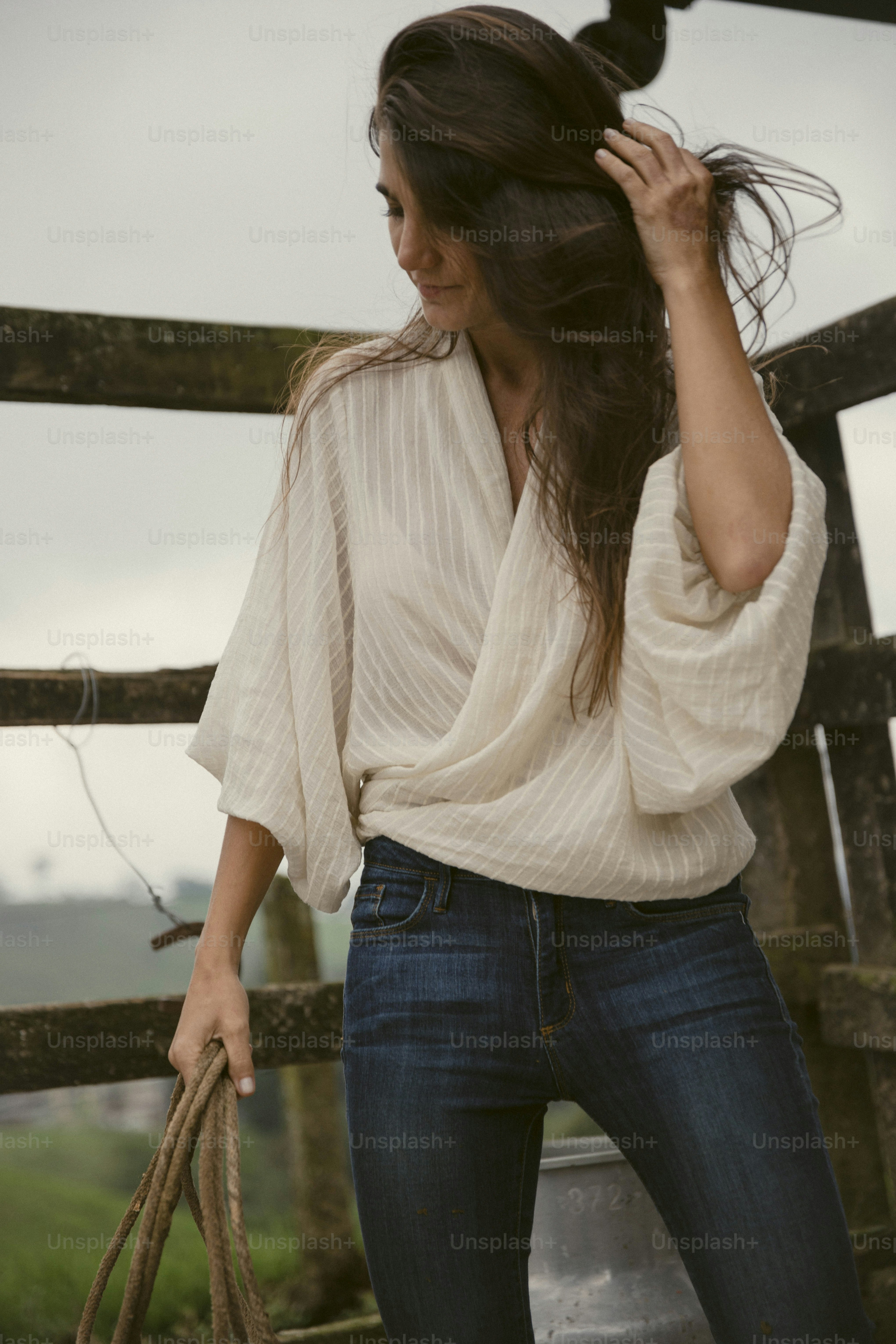 a woman in a white top holding a brown bag