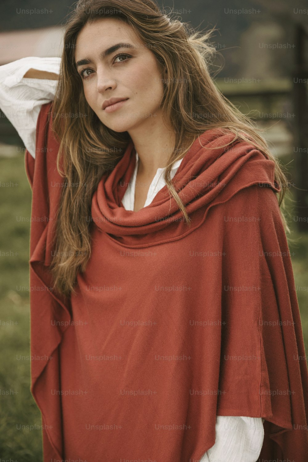 uma mulher vestindo um pônei vermelho em pé em um campo