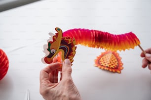 une personne tenant une décoration en papier en forme de dragon