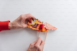 a person is holding a paper dragon on a stick