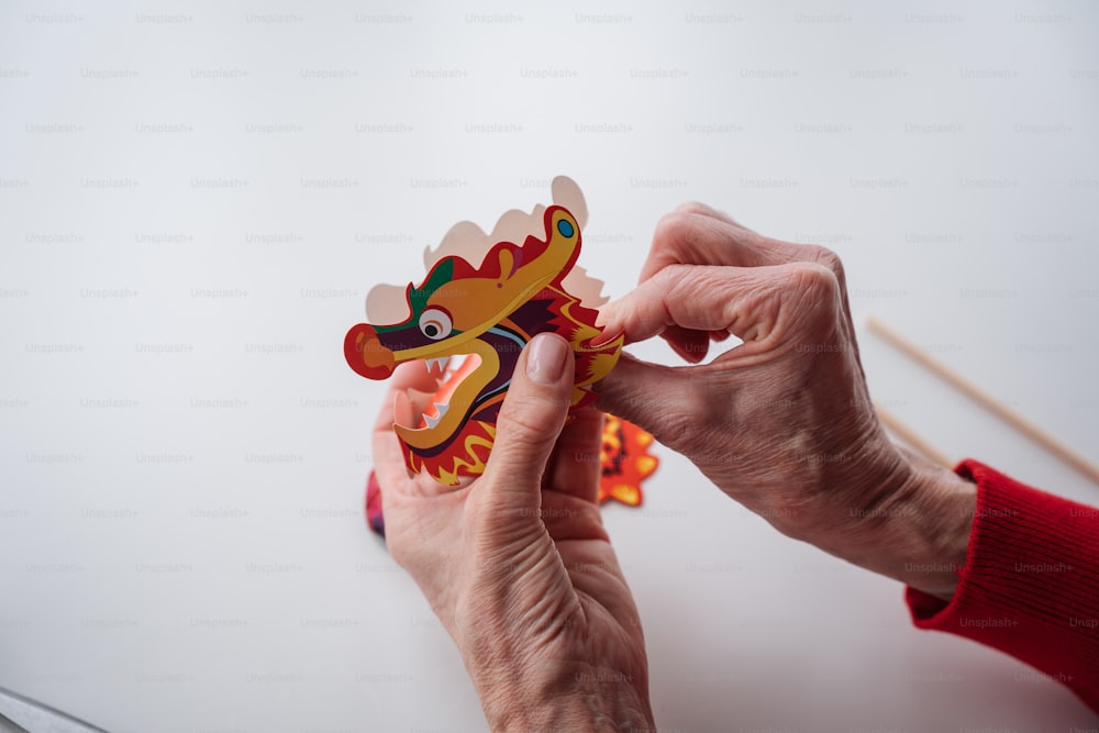 a person holding a wooden toy with a dragon on it