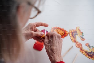 uma mulher está pintando um dragão em uma parede