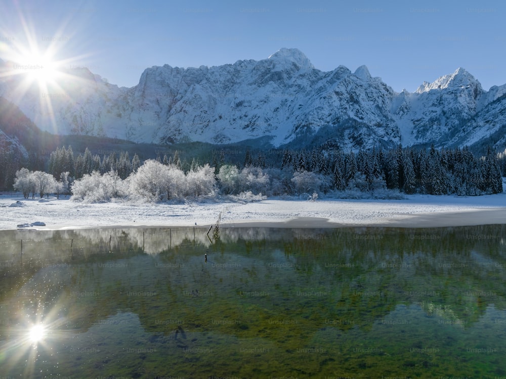 the sun shines brightly over a mountain lake