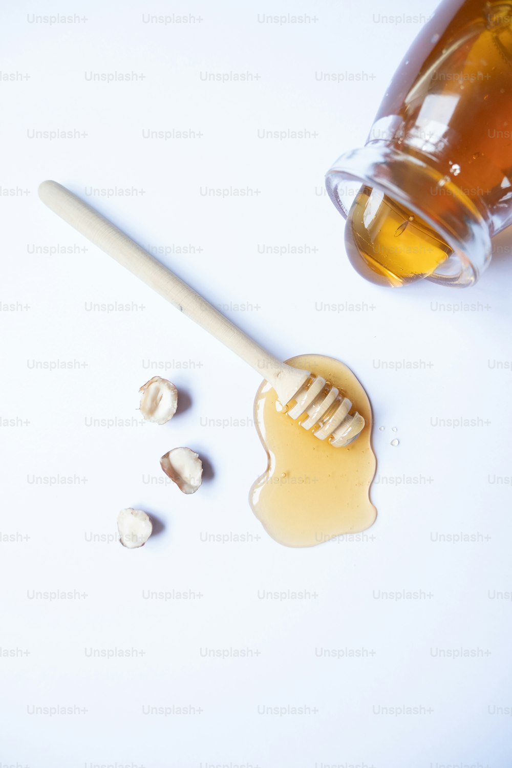 um molho de mel com uma colher de pau ao lado