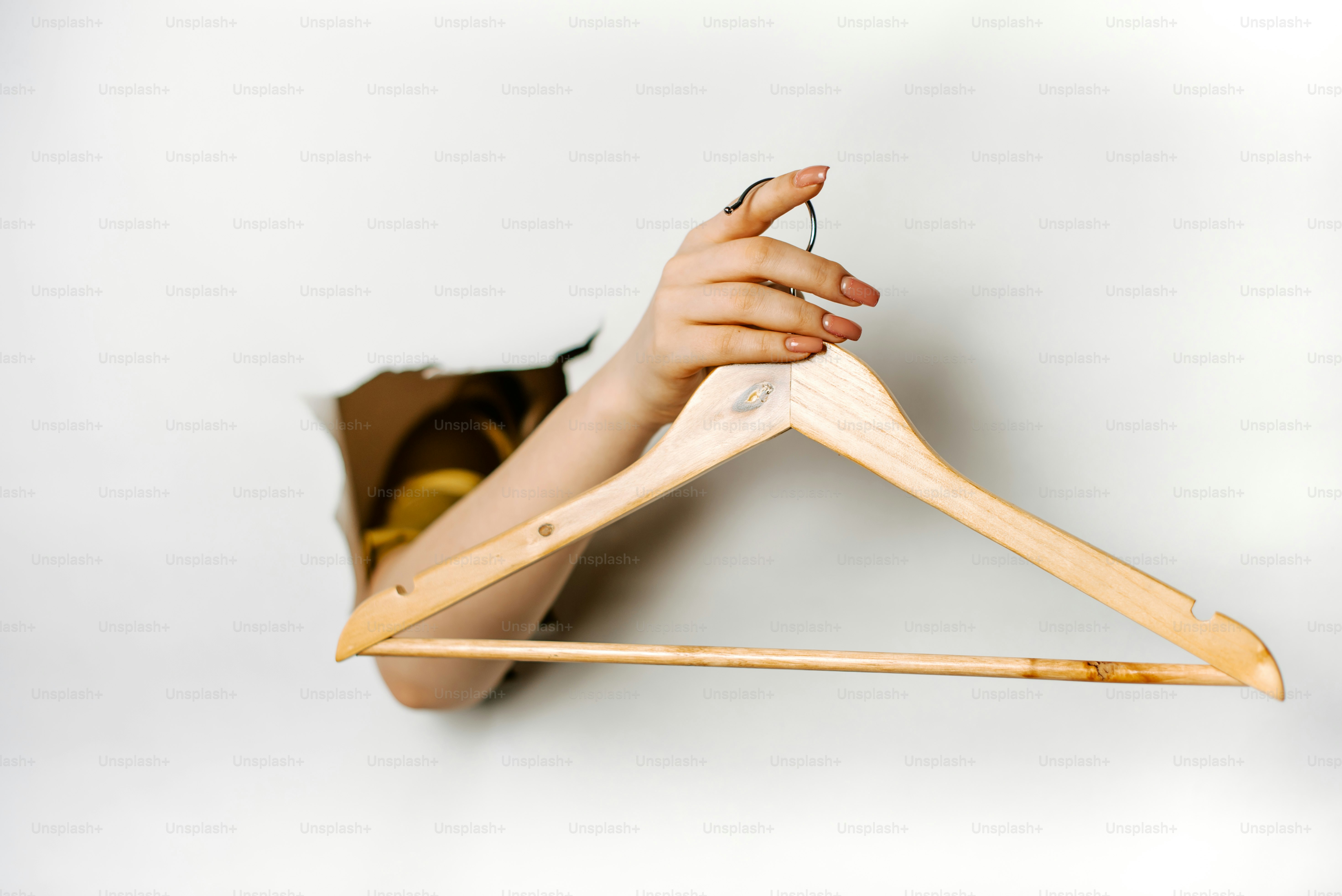 Eine Frau hält einen hölzernen Kleiderbügel