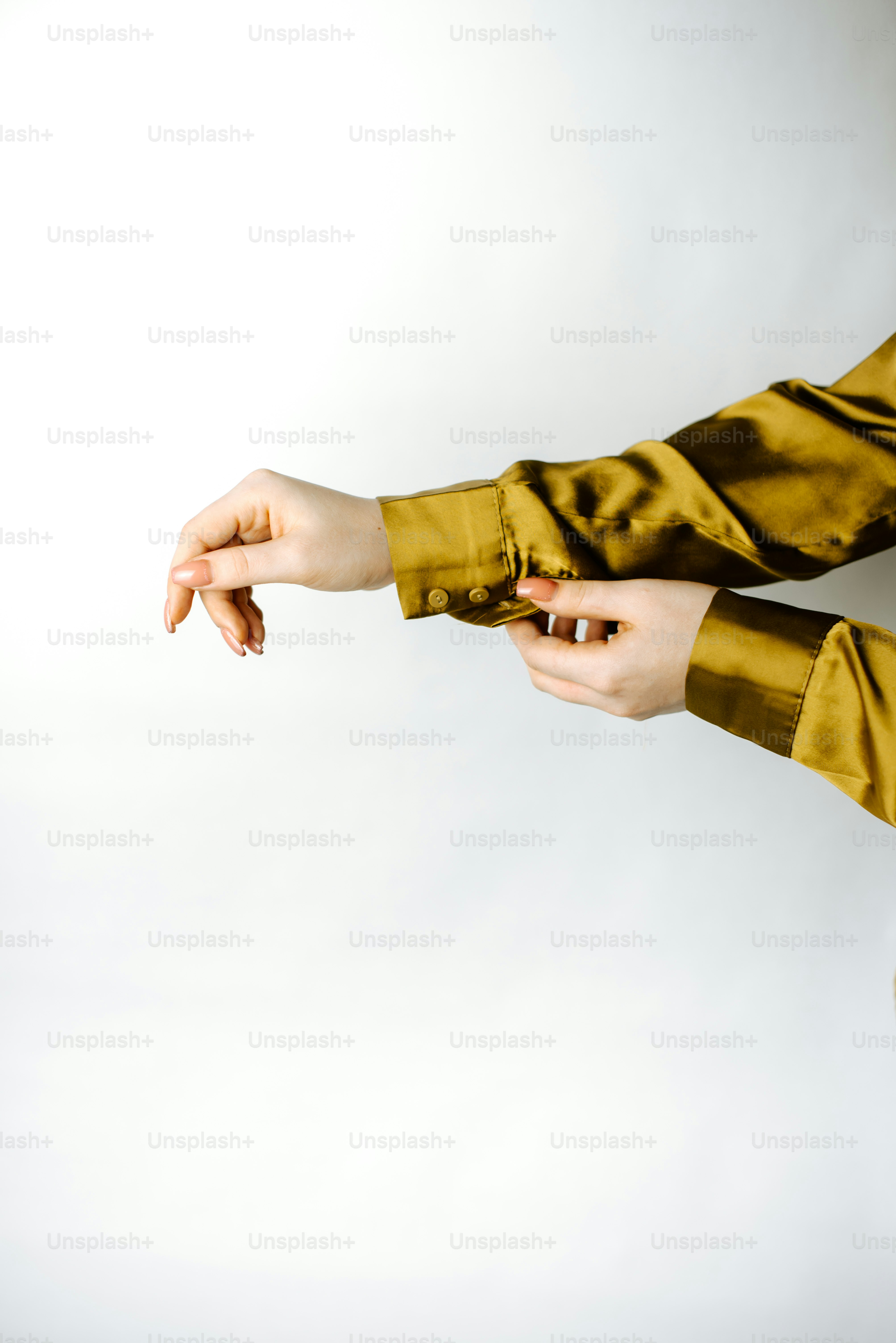 Eine Frau in einem goldenen Oberteil hält ein Handy in der Hand