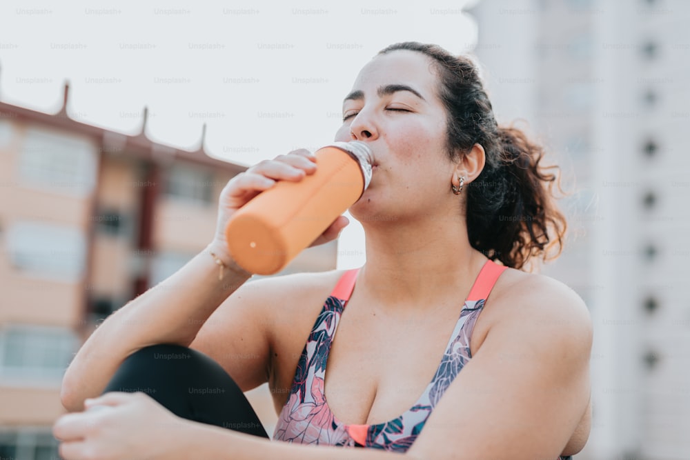 a woman in a bikini drinking from a bottle