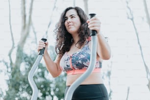 a woman in a sports bra top is using a stationary exercise machine