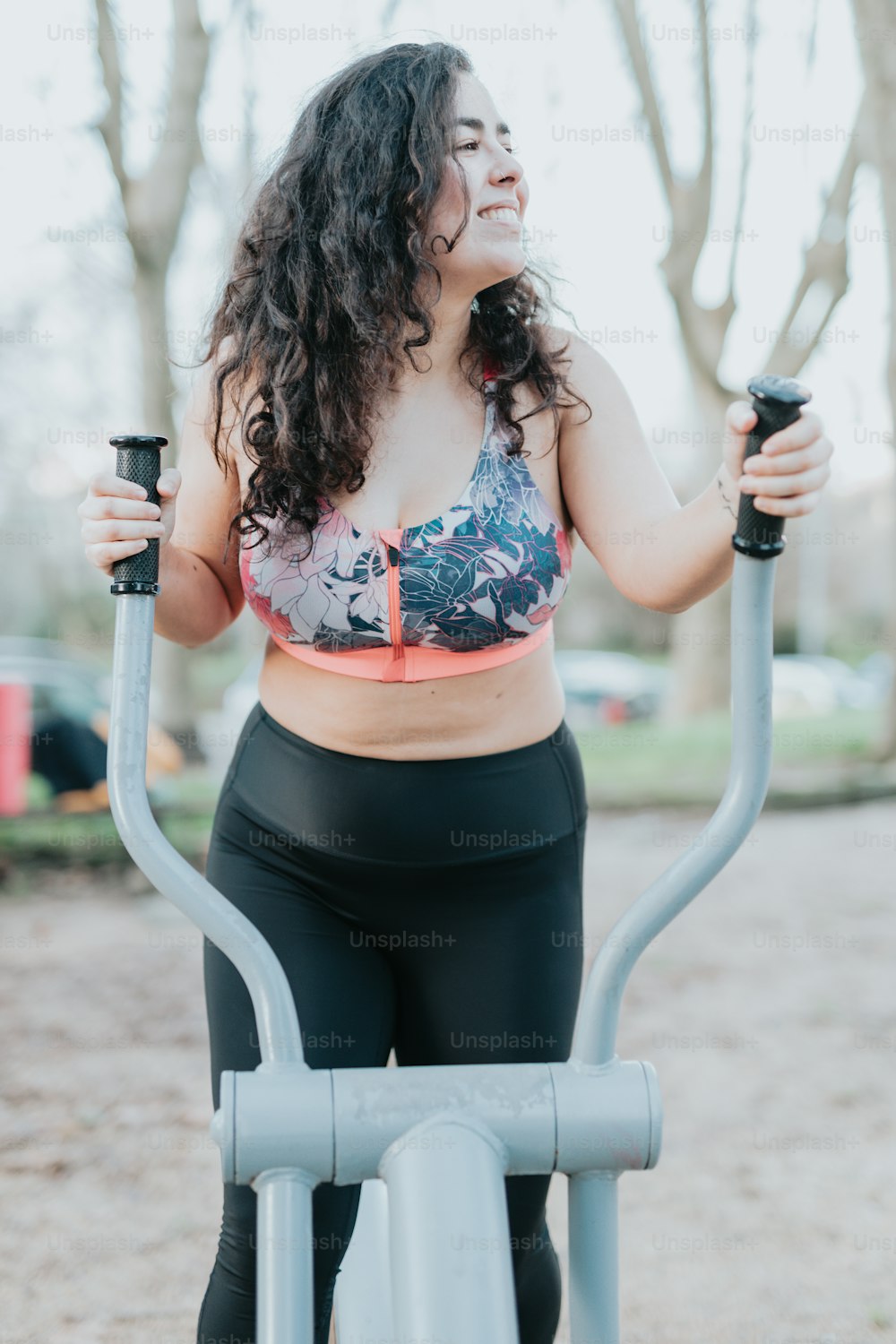 a woman on a stationary exercise bike in a park