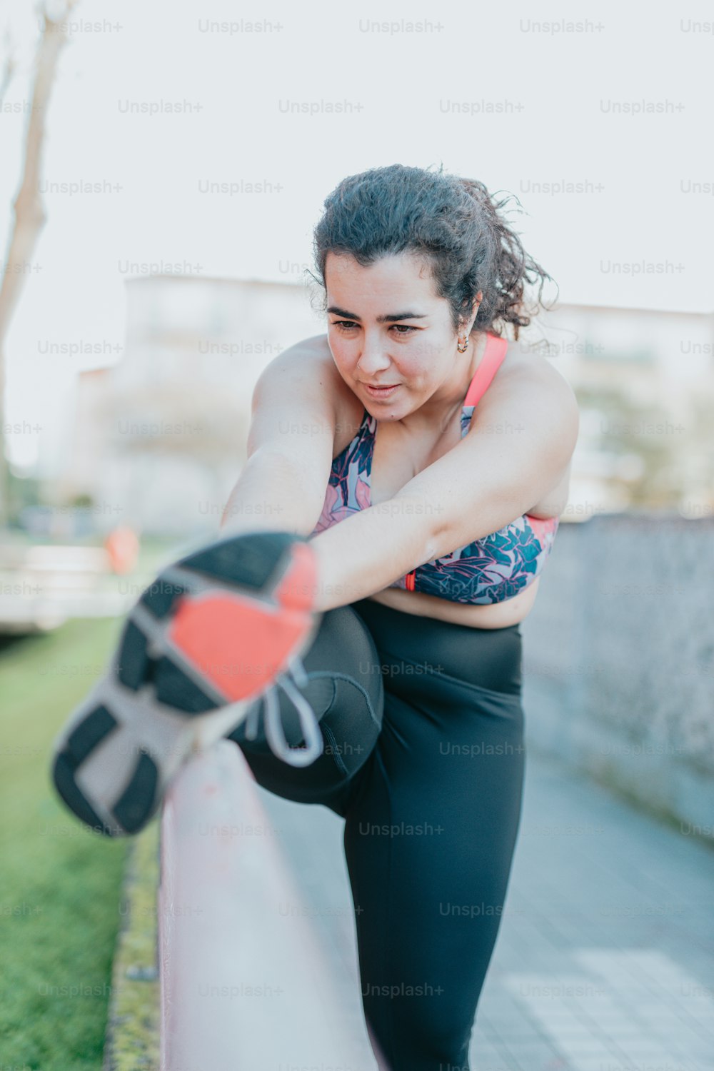 A woman in a sports bra top leaning against a fence photo – Working out  Image on Unsplash