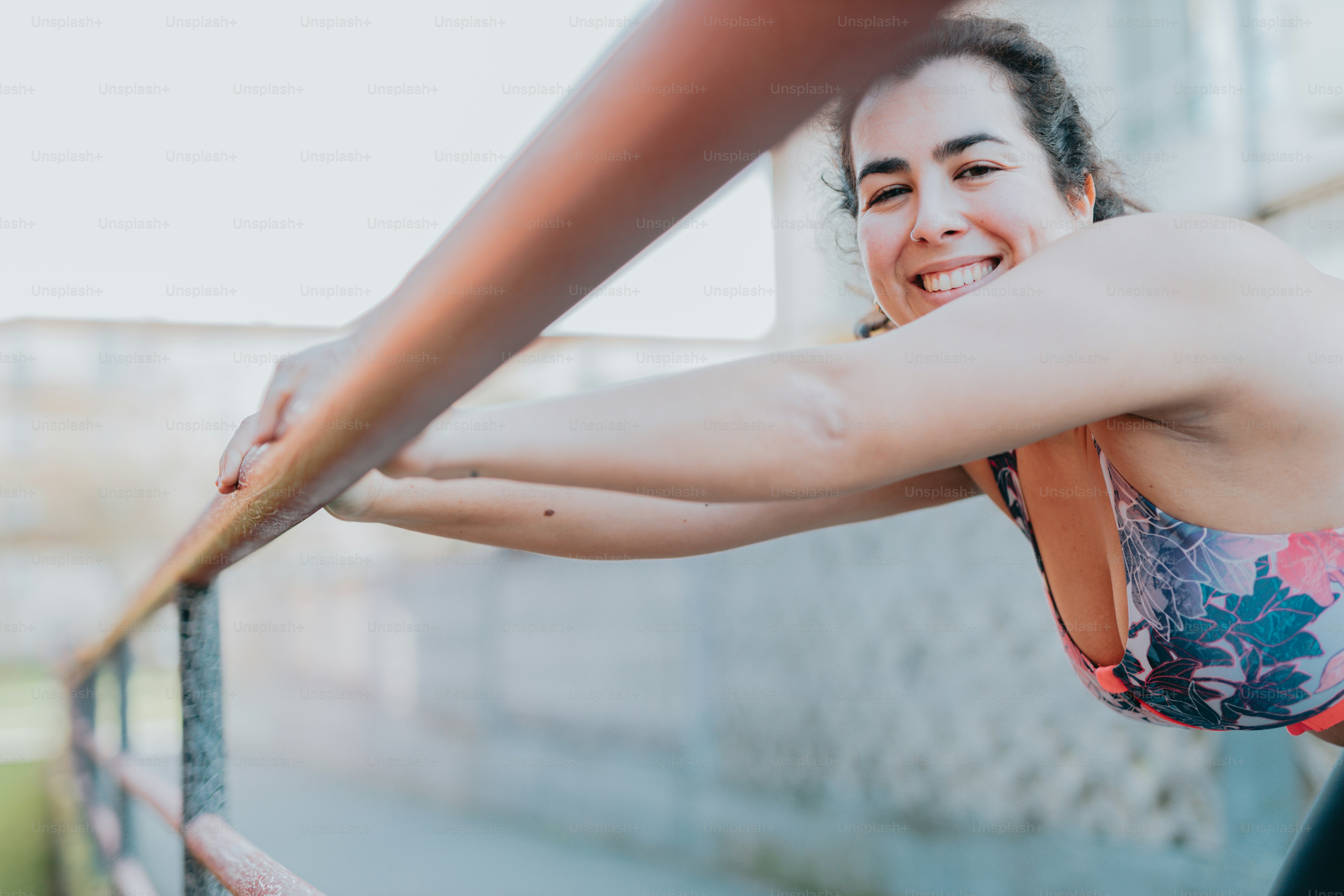 a woman leaning on a rail smiling at the camera