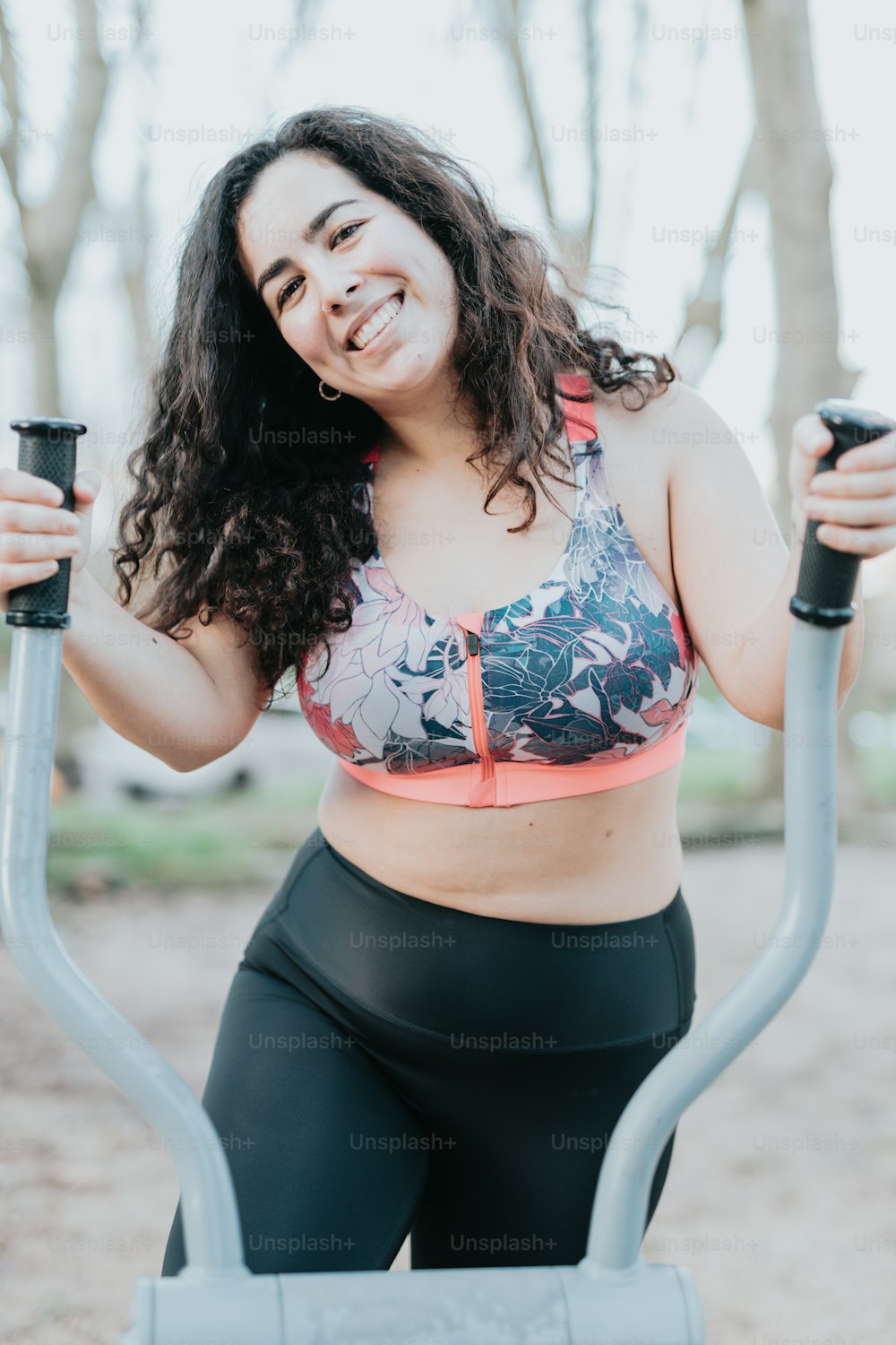 A woman in a sports bra top leaning against a fence photo – Working out  Image on Unsplash