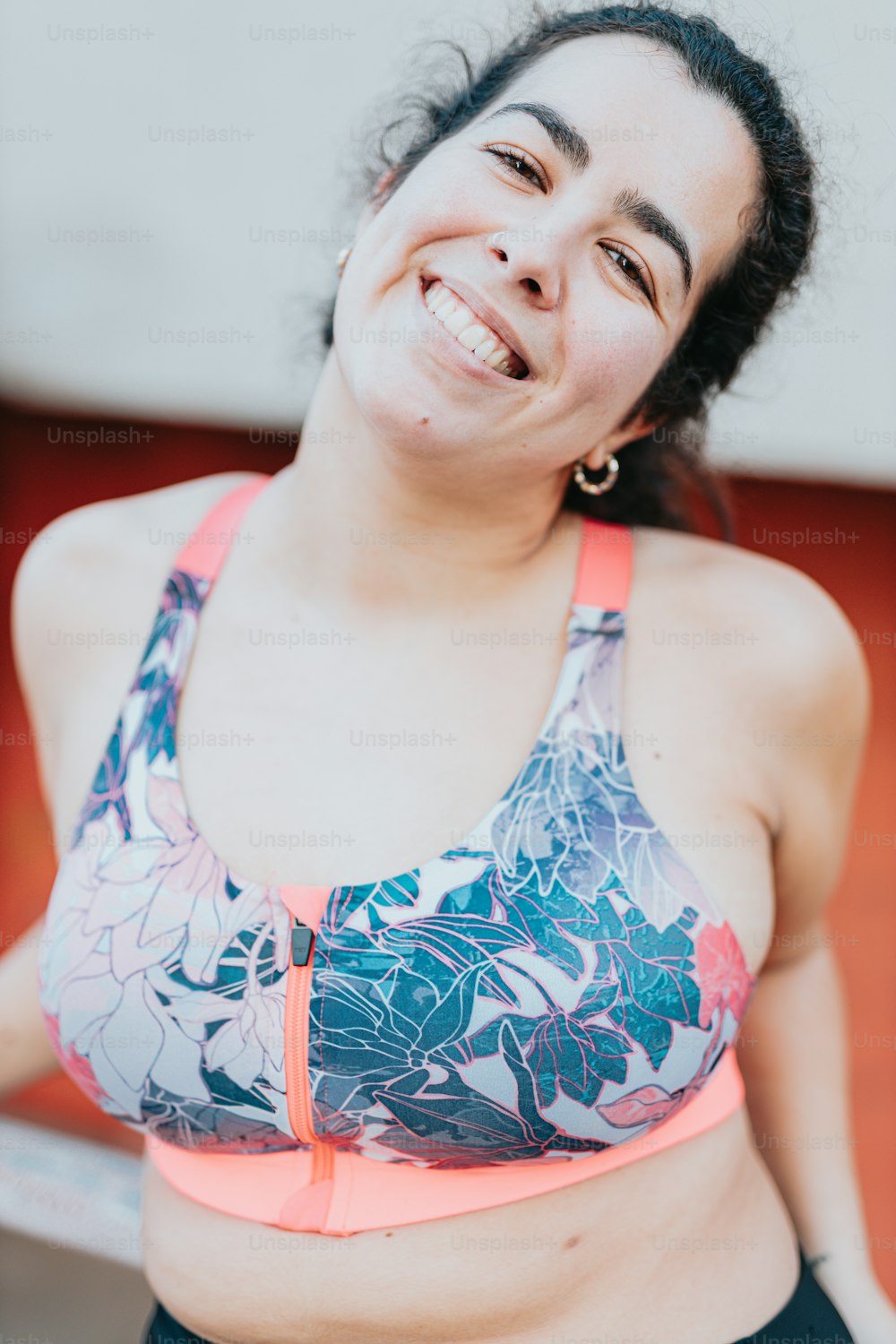 a woman in a sports bra smiling at the camera