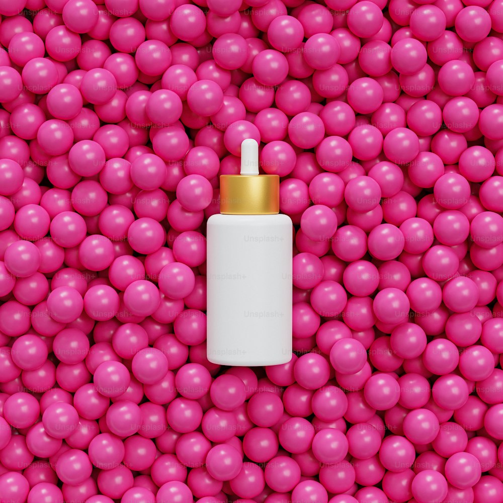 Eine Flasche mit goldenem Verschluss, umgeben von rosa Kugeln