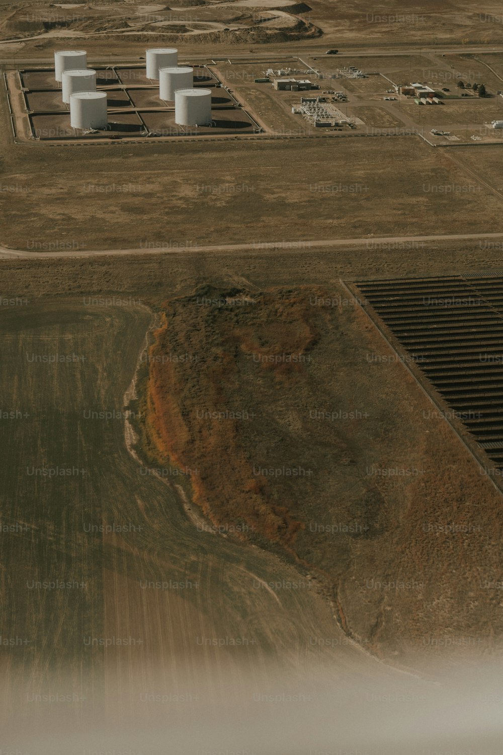 an aerial view of a large field and a power plant