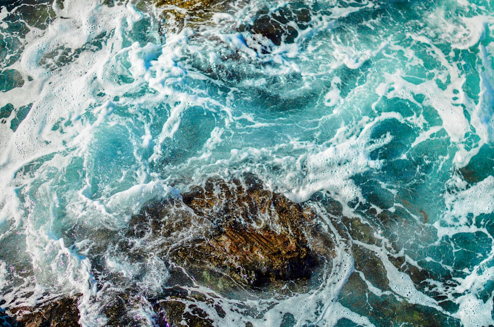 an aerial view of the ocean waves and rocks