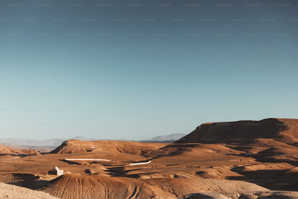 uma vista de um deserto com uma montanha no fundo