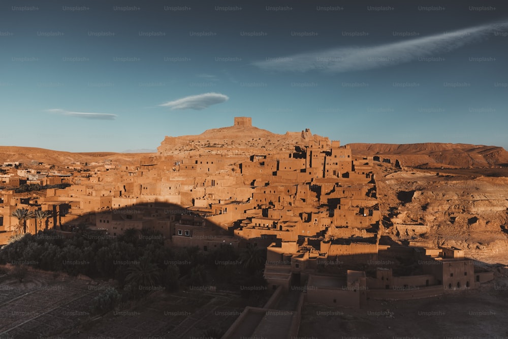 a village in the desert with a mountain in the background