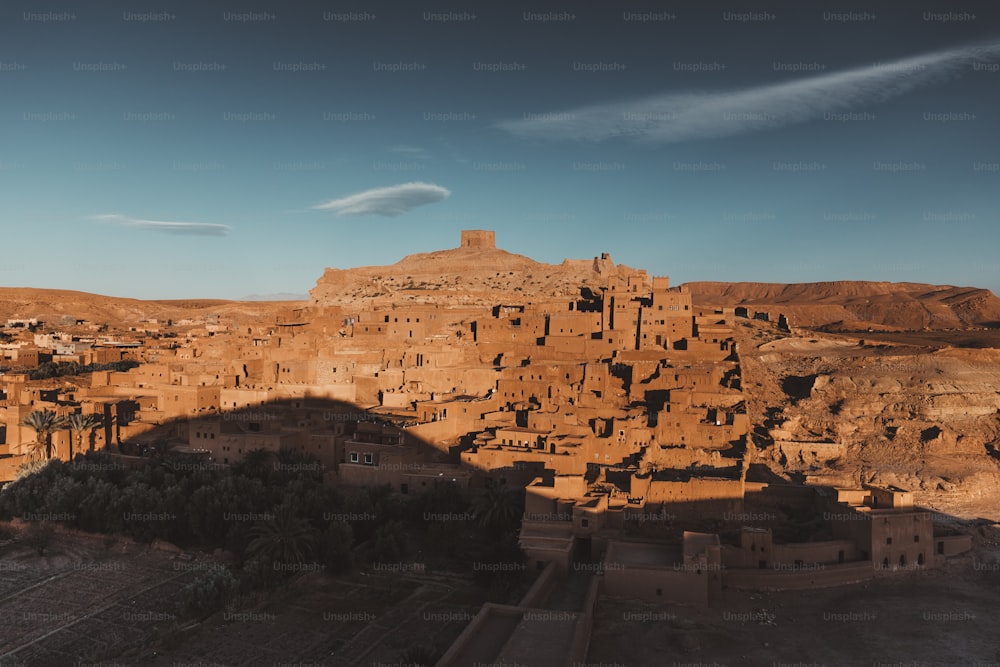 a village in the desert with a mountain in the background