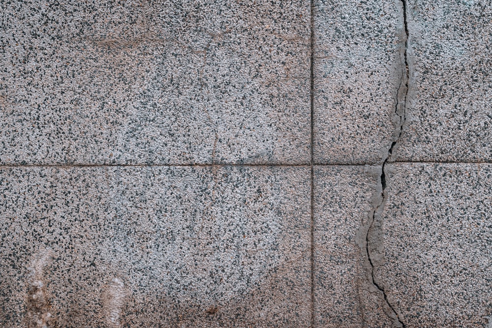 a close up of a stone wall with cracks in it