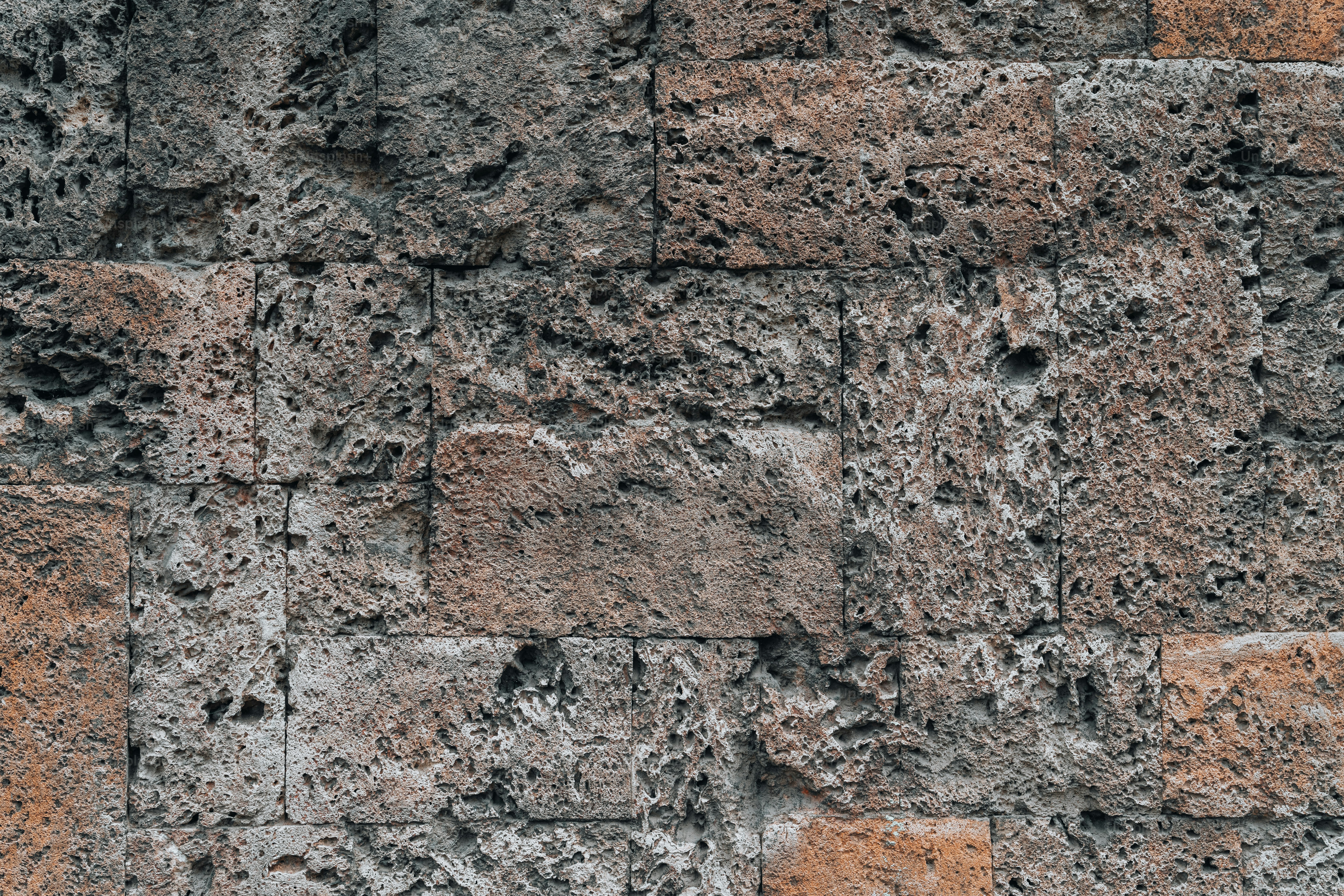 a close up of a brick wall with small holes in it