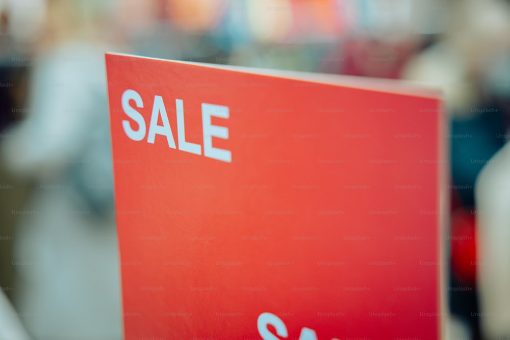 a red sale sign sitting on top of a table