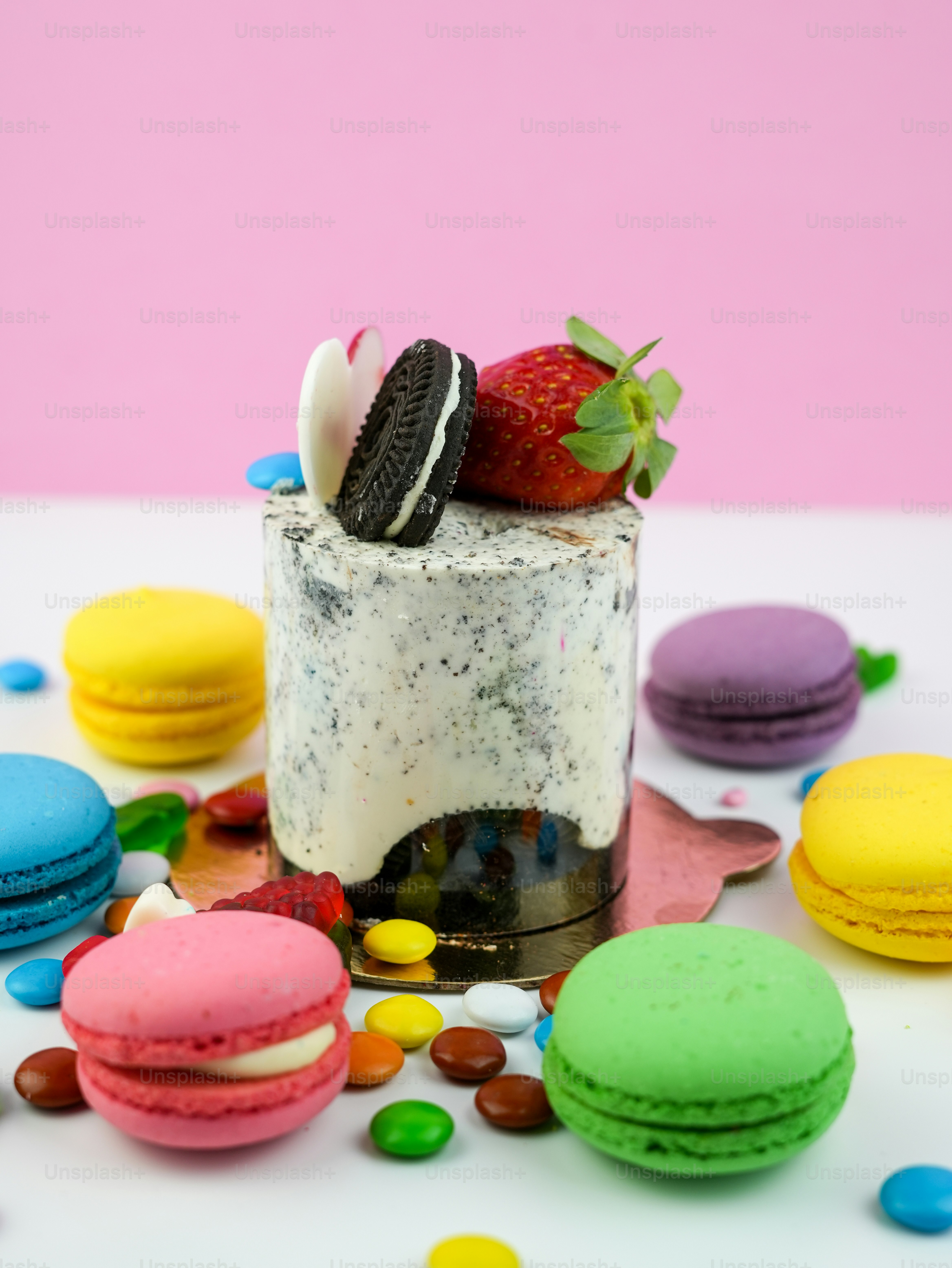 a cake with a strawberry on top of it surrounded by macaroni and cheese