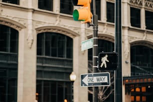 a traffic light and a one way sign on a pole
