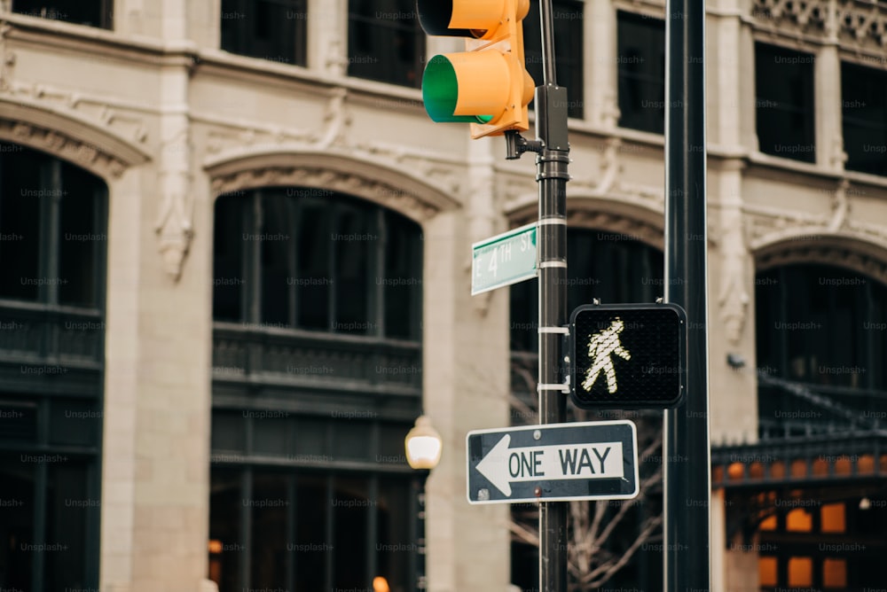 a traffic light and a one way sign on a pole