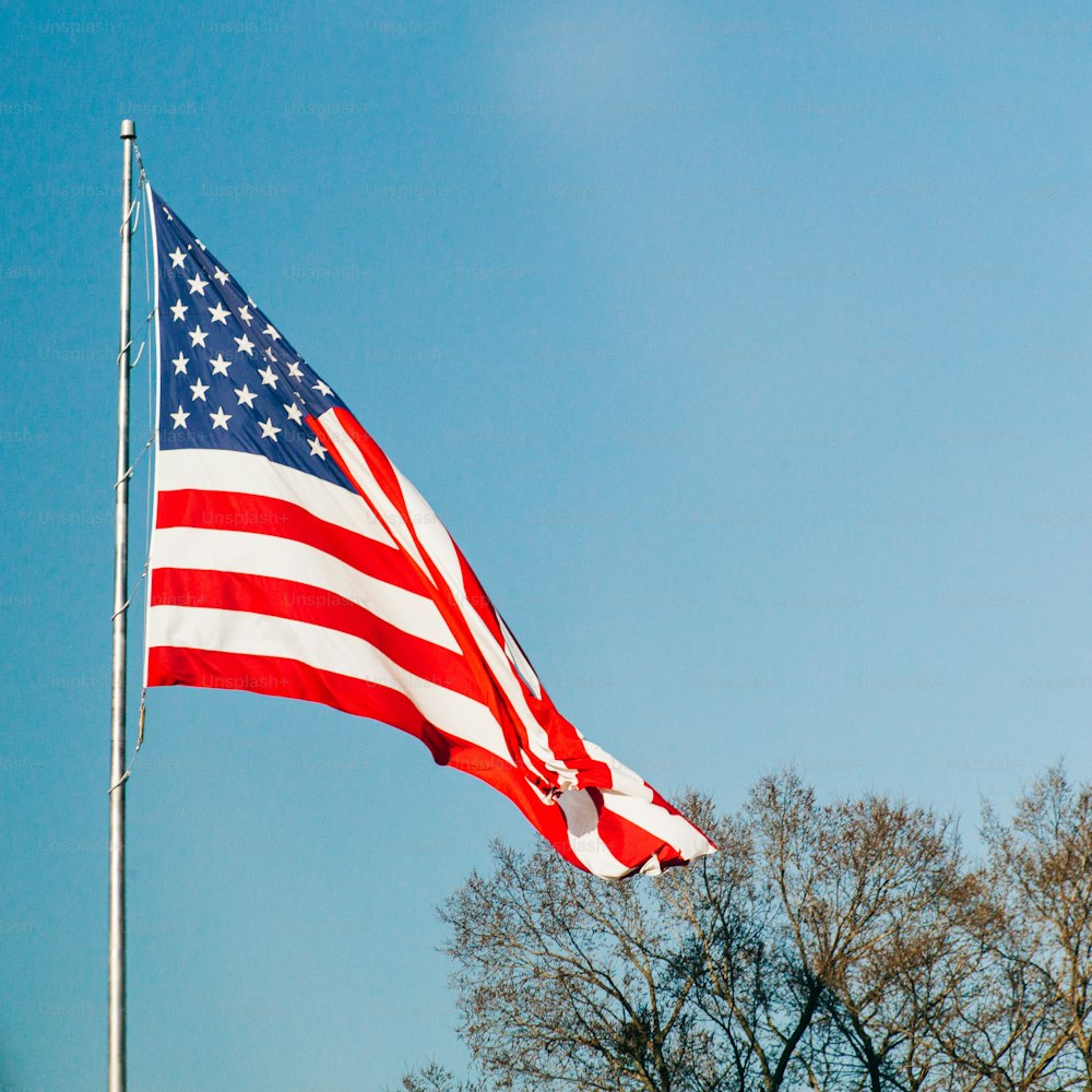 a large american flag flying in the wind