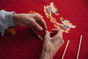 a person is making a dragon decoration on a table