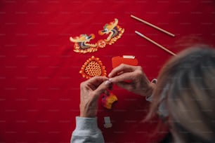 a woman is working on a dragon decoration