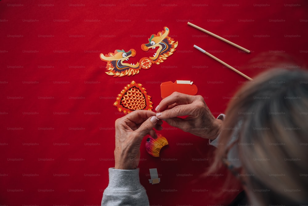 a woman is working on a dragon decoration
