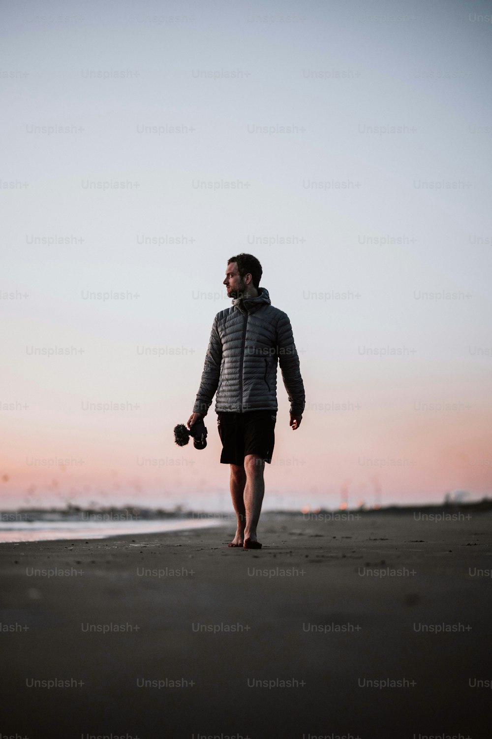 a man walking on a beach holding a pair of dumb dumb dumb dumb dumb dumb